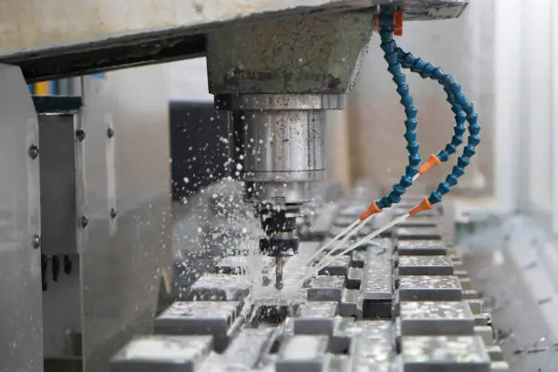 Close up on an industrial drill Spindle inside a production line, tools are water cooled. No people are visible.