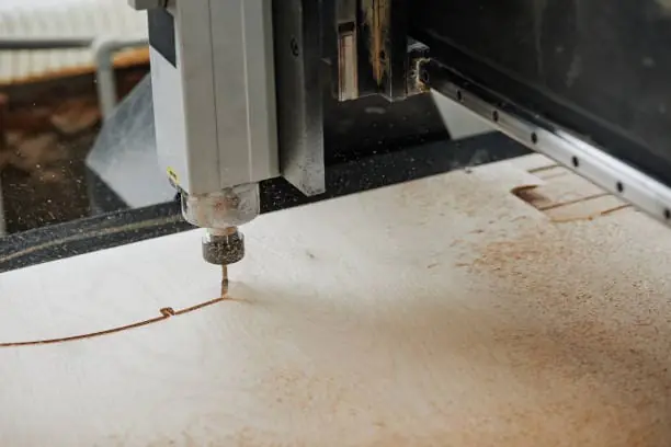 El husillo CNC está trabajando en el tablero de madera.