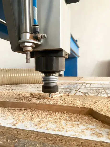 El husillo CNC está trabajando en el tablero de madera.